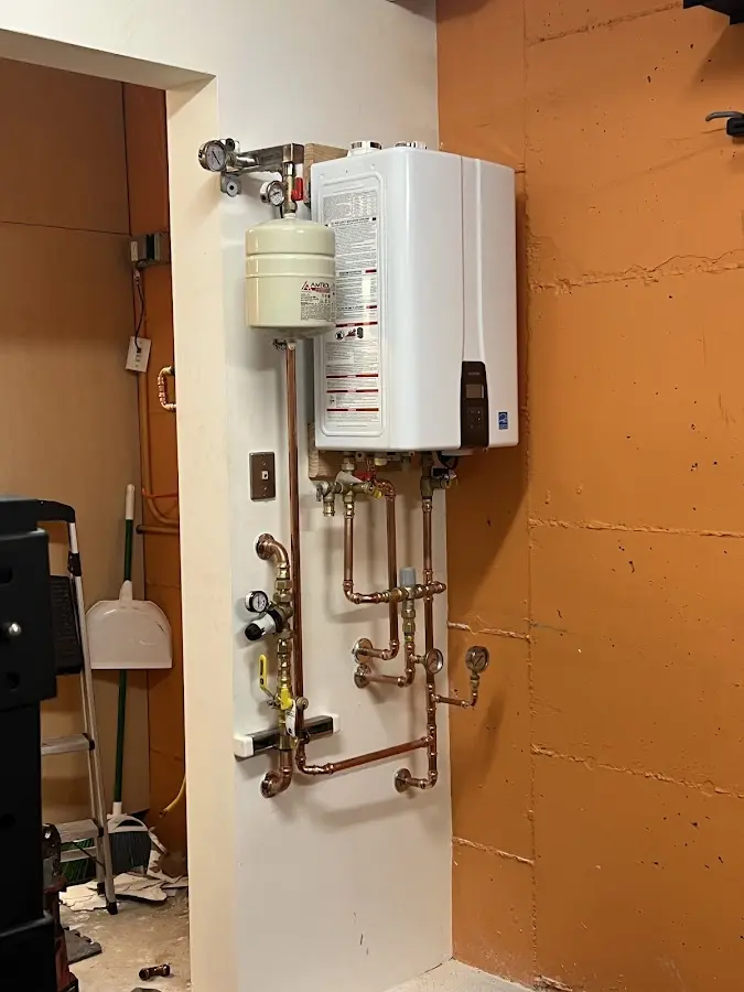 Plumbing technician inspecting water heater connections in Charter Oak